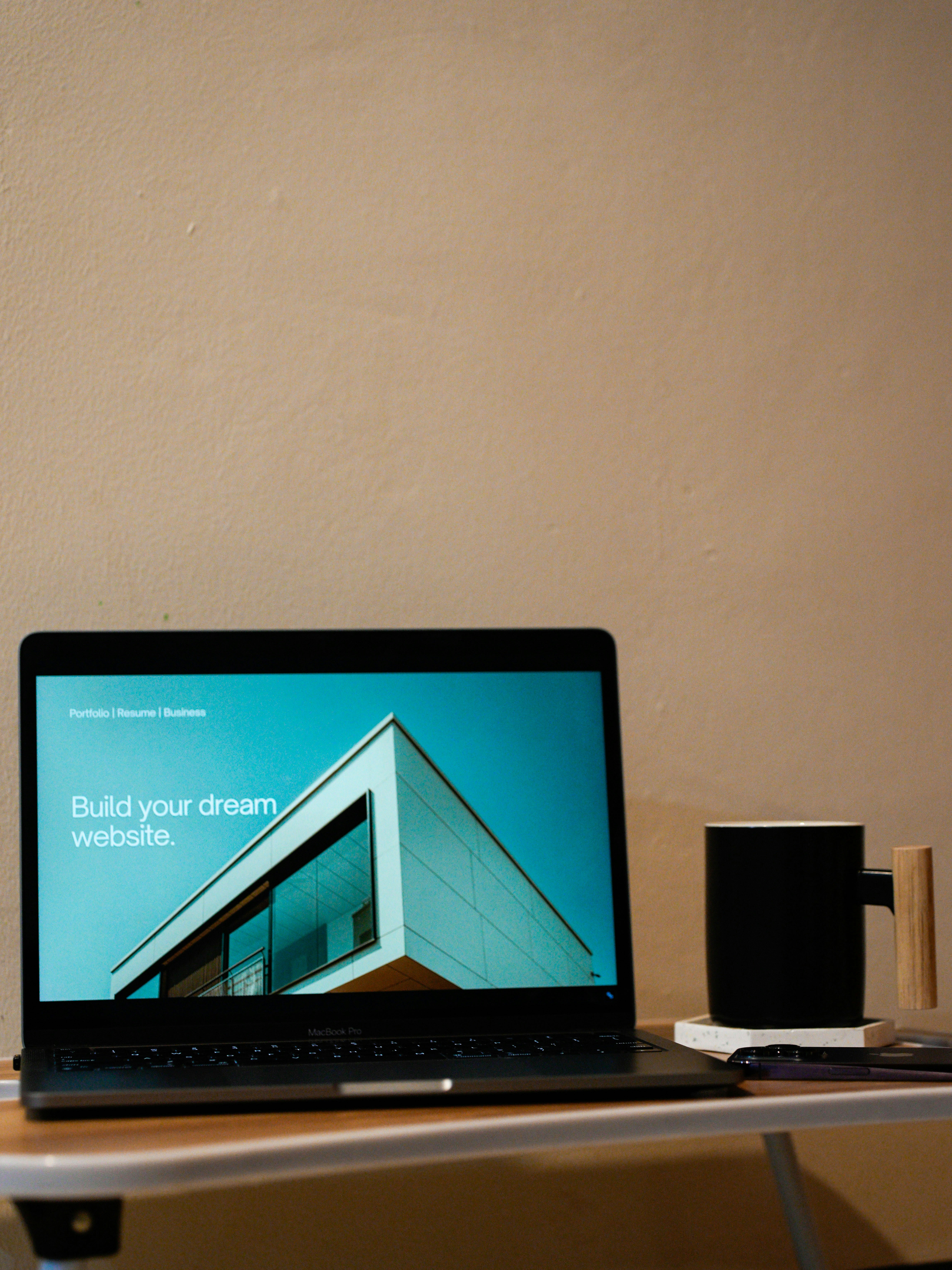 a laptop open to a beautiful website, that says 'Build your dream website.'